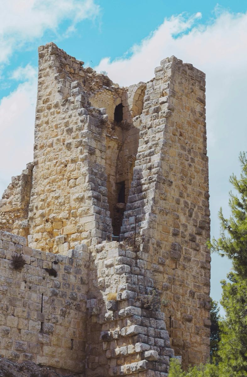 Stone tower of Ajloun Castle rising against a blue sky in northern Jordan