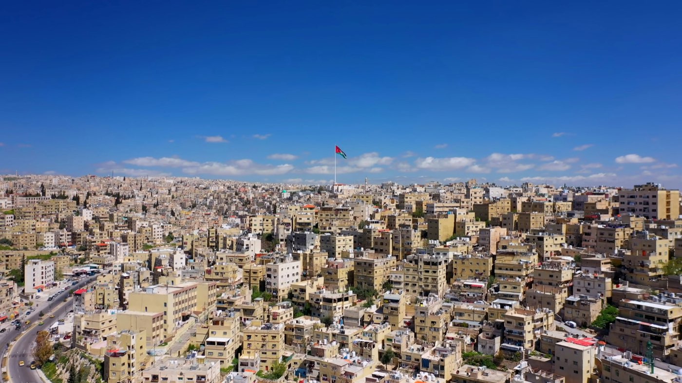Amman city skyline at dusk with residential buildings spread across the hills