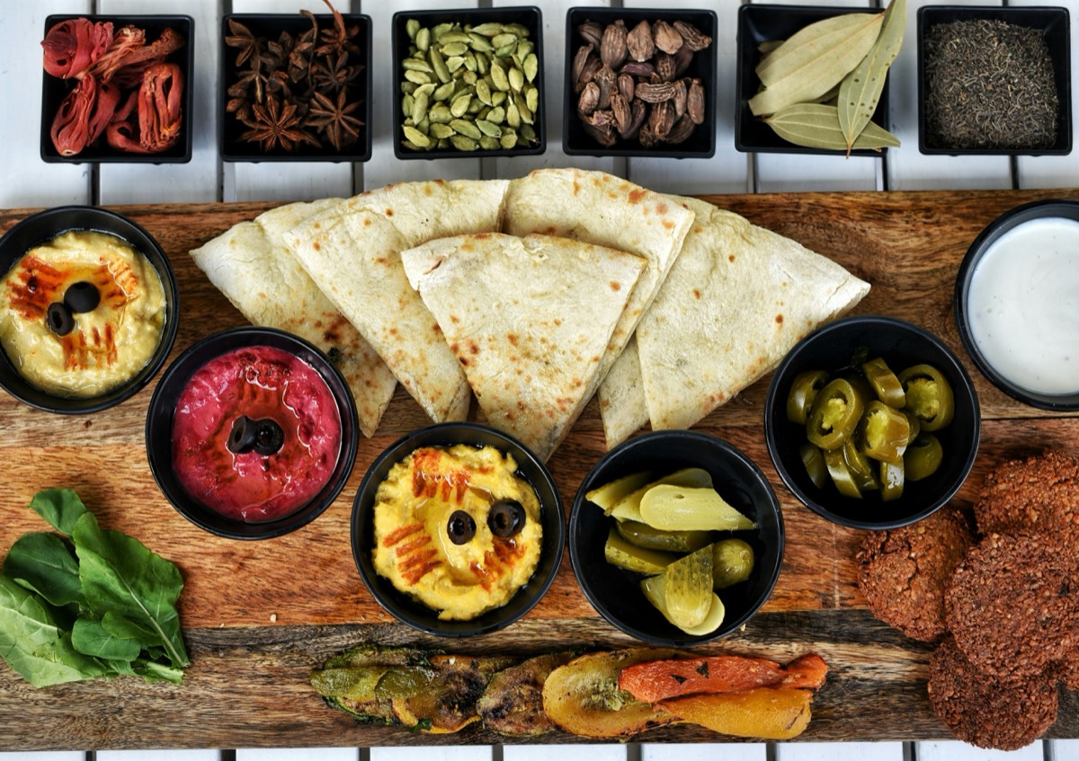 Jordanian home-cooked meal with flatbread, hummus and local herbs on a wooden table