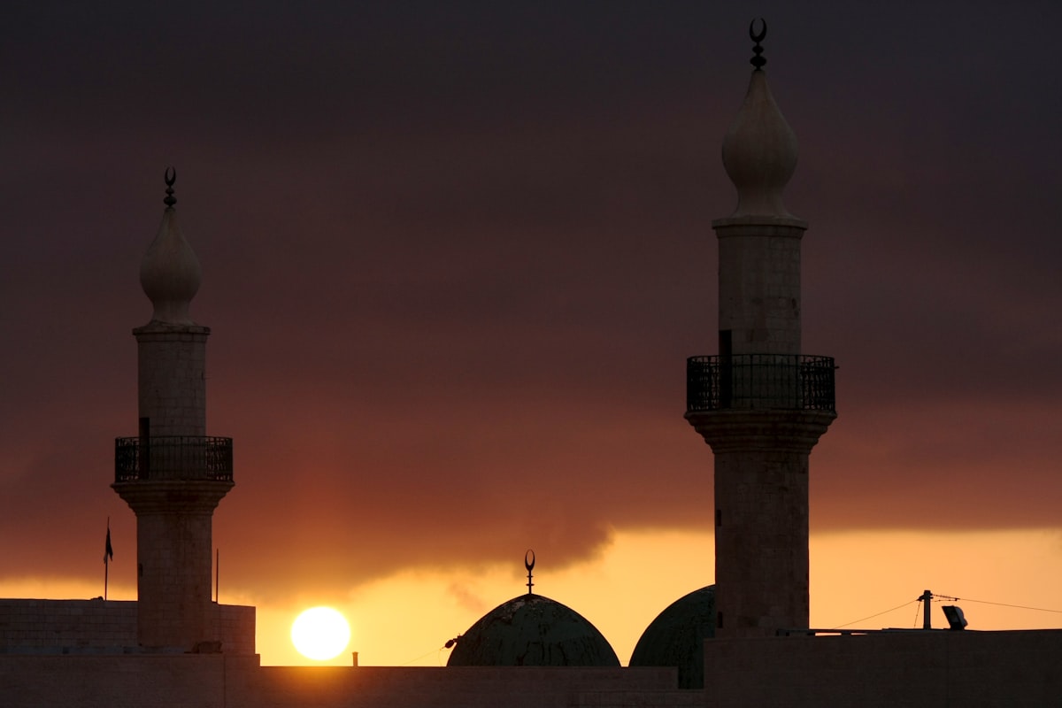 Silhouette of mosque minarets and dome at sunset in Jordan