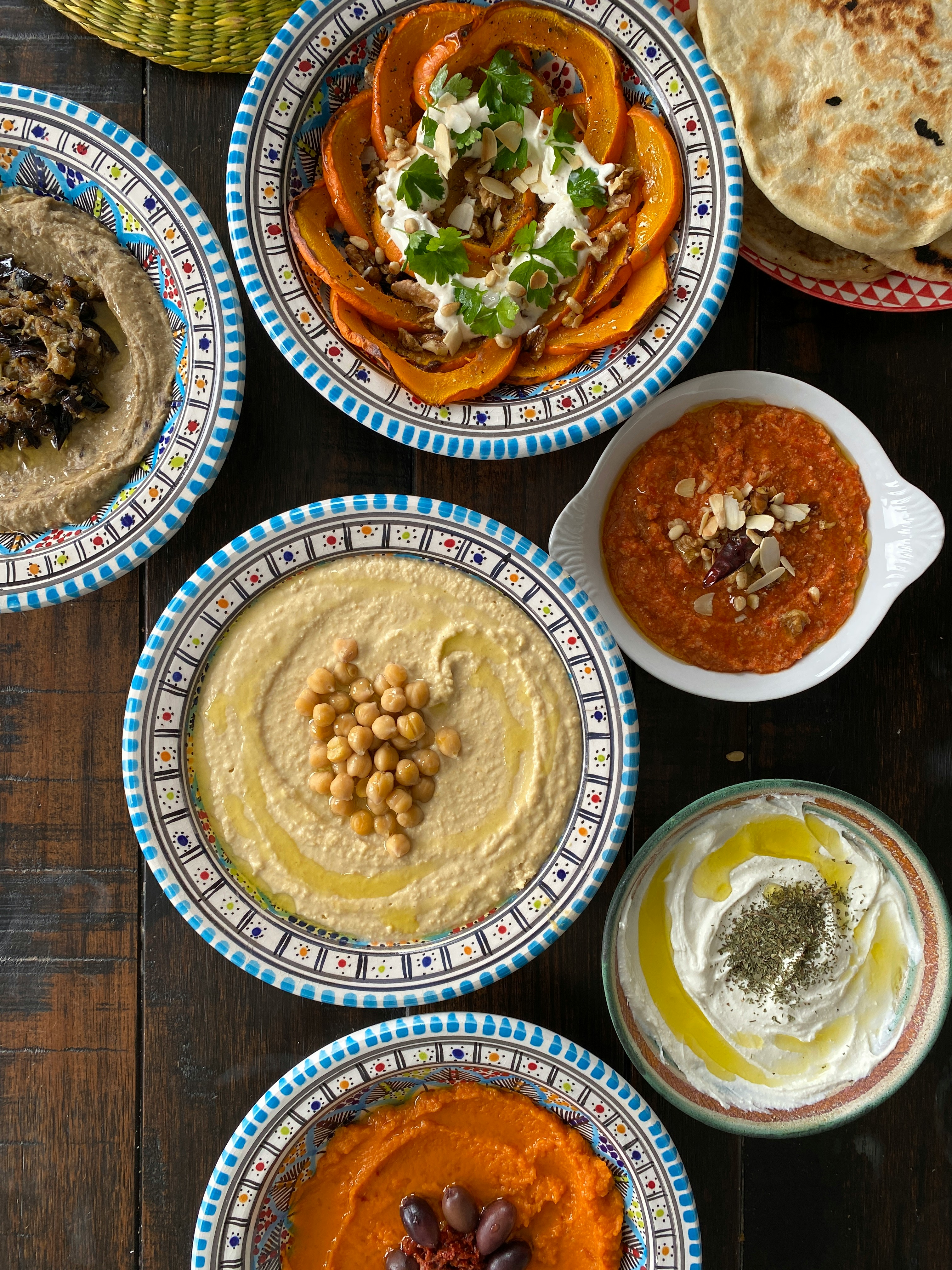 A spread of plant-based mezze dishes — hummus, moutabbal, fattoush, and tabbouleh