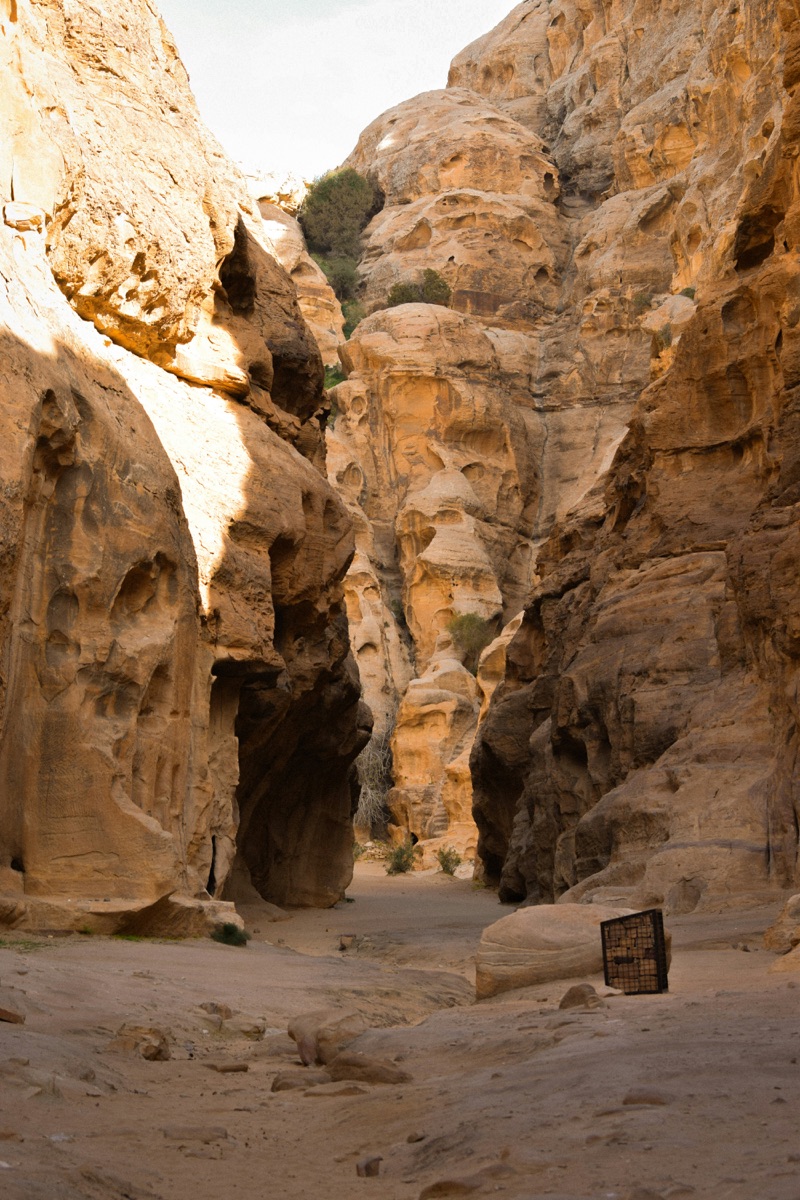 Narrow sandstone canyon at Little Petra (Siq al-Barid) with carved Nabataean facades