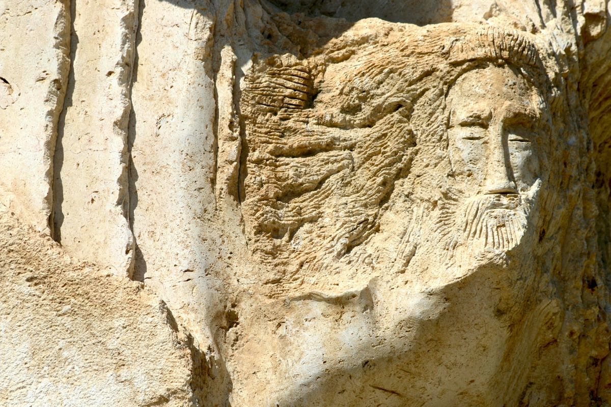 Ancient carved stone face relief in Madaba, Jordan — a remnant of the city's pre-Islamic heritage