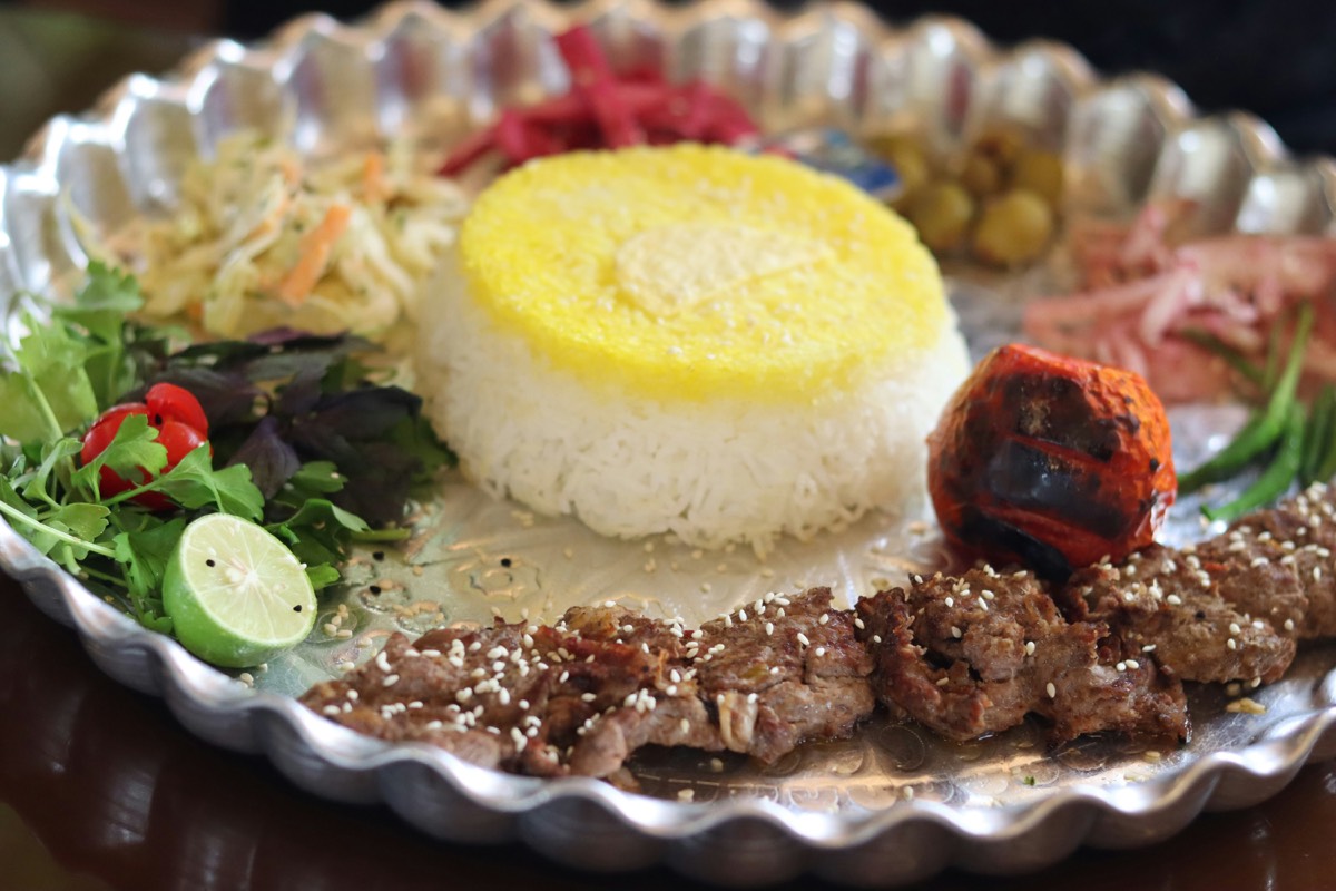 Jordanian lunch spread with flatbread, hummus and grilled meat on a stone table