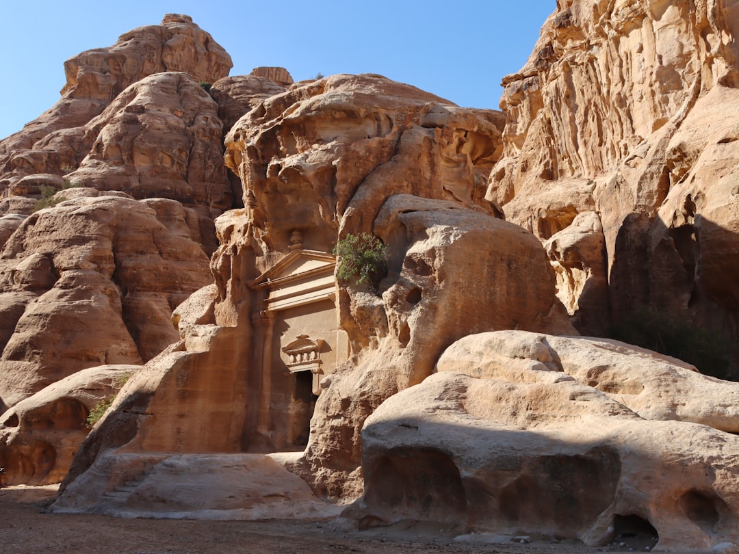 A carved Nabataean building nestled into sandstone boulders at Little Petra (Siq al-Barid), Jordan