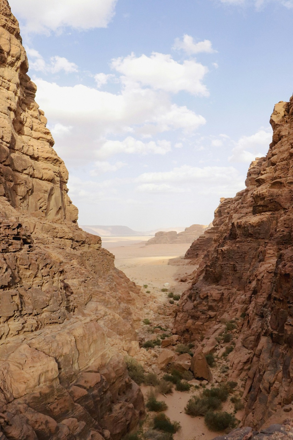 Rocky canyon walls opening onto the vast Wadi Rum desert plain, Jordan