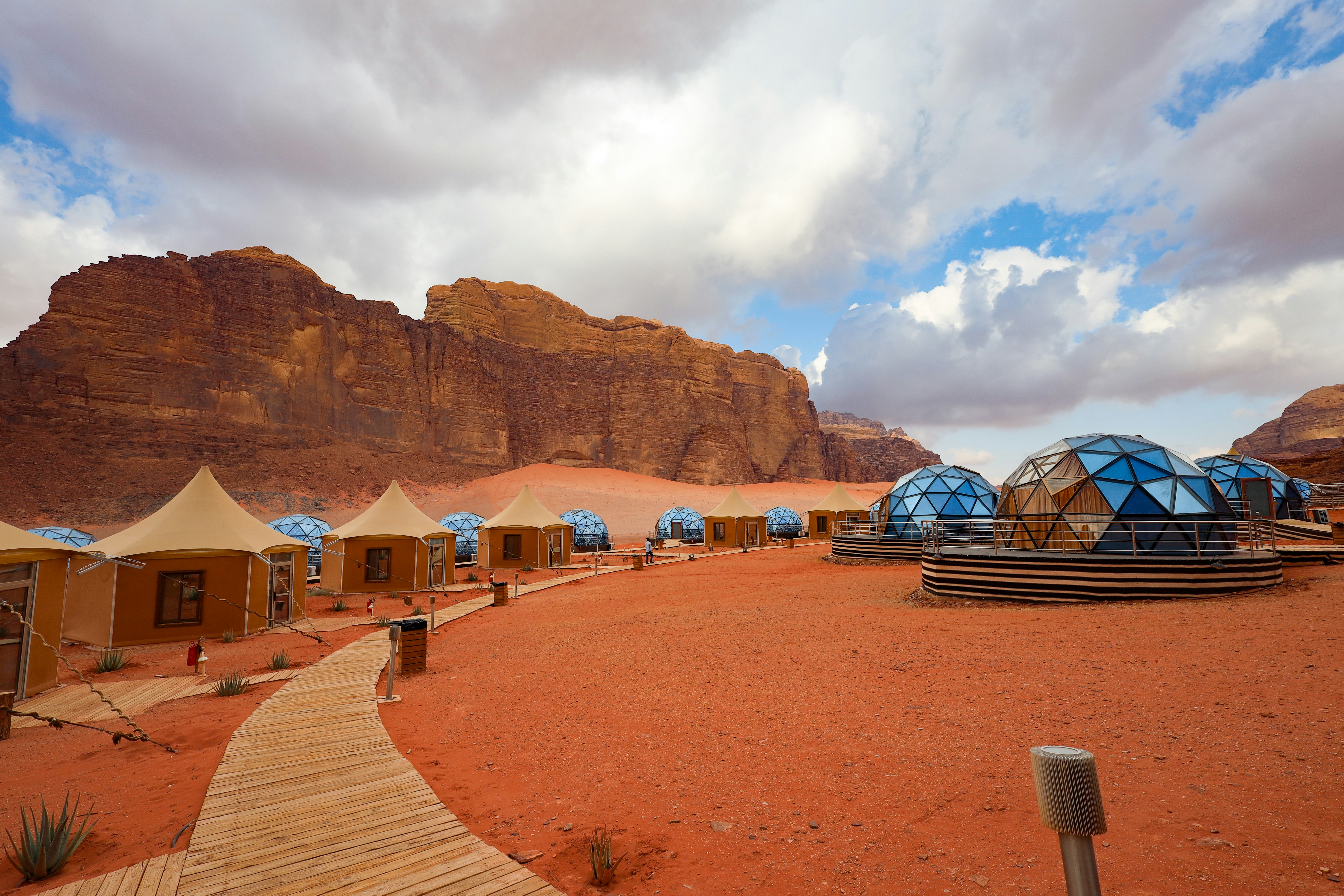 Luxury glamping camp with dome tents and a wooden walkway in Wadi Rum, Jordan