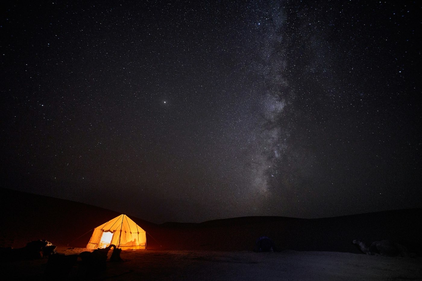 A glowing Bedouin tent under the Milky Way in Wadi Rum desert, Jordan