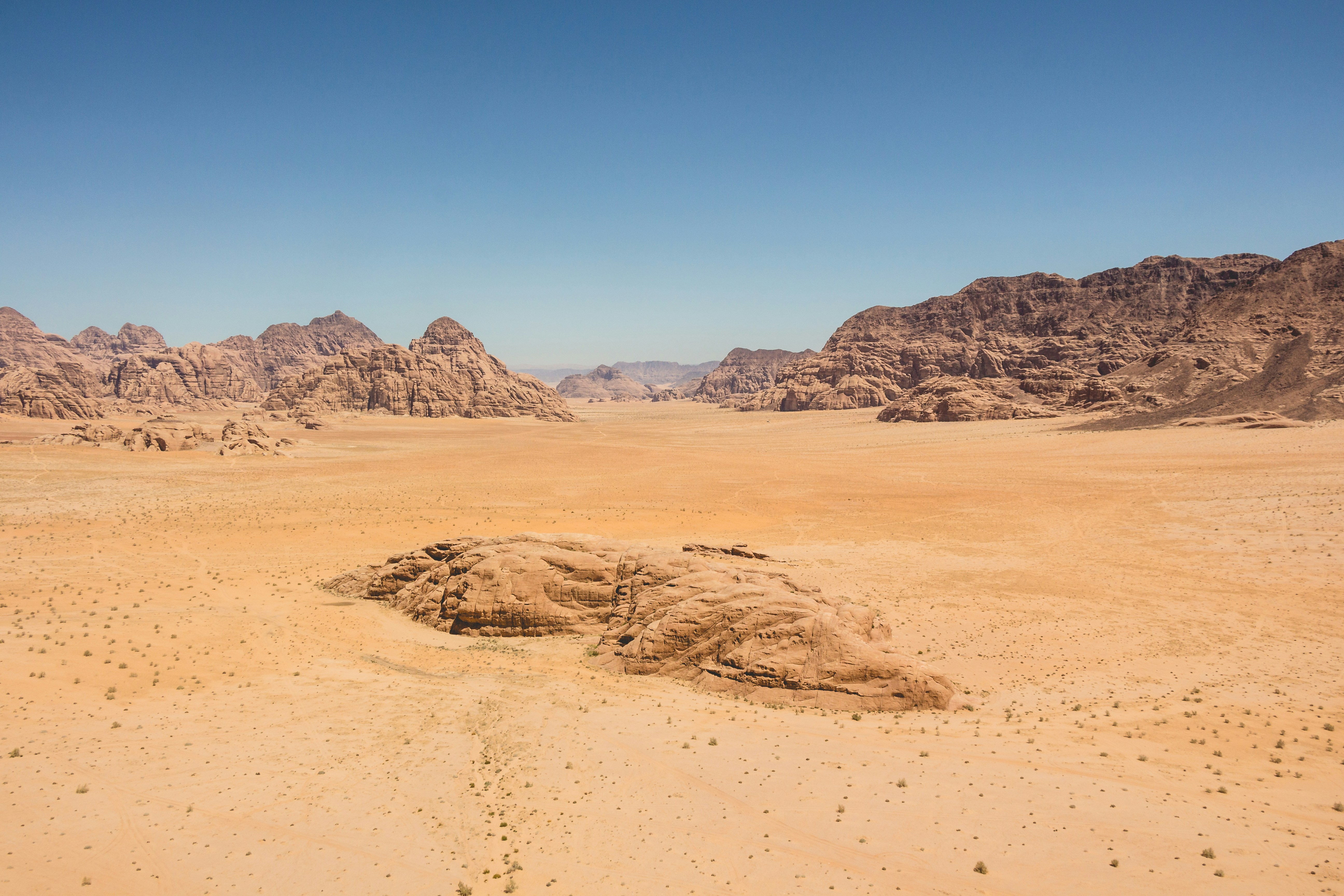 Hot air balloon drifting over the red sandstone landscape of Wadi Rum at sunrise